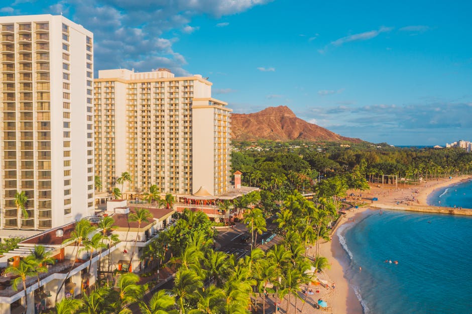 Aerial view of Waikiki beach and luxury hotel with Diamond Head in background.