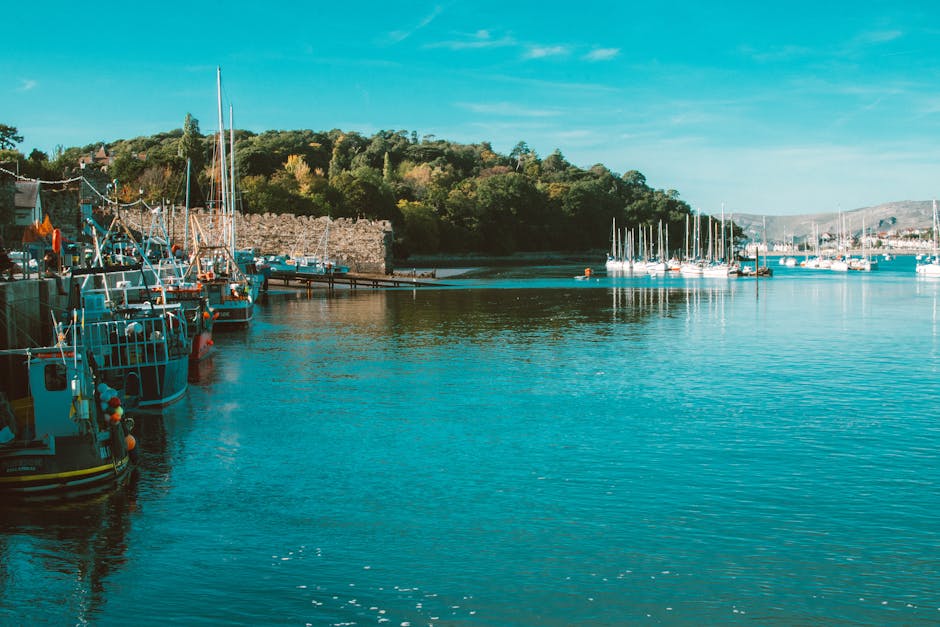 Beautiful Conwy Harbor with boats moored along the dock, framed by historic castle walls in North Wales.