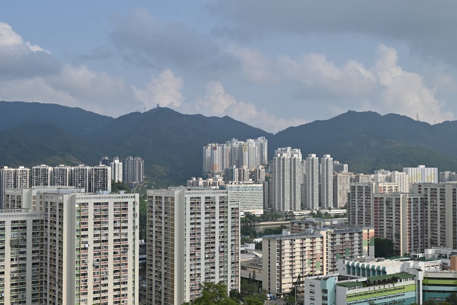 A wide view of Hong Kong's urban landscape featuring skyscrapers against a mountain backdrop.