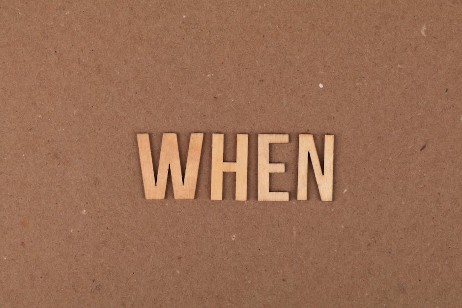 Wooden letters forming the word 'When' on a plain cardboard background.